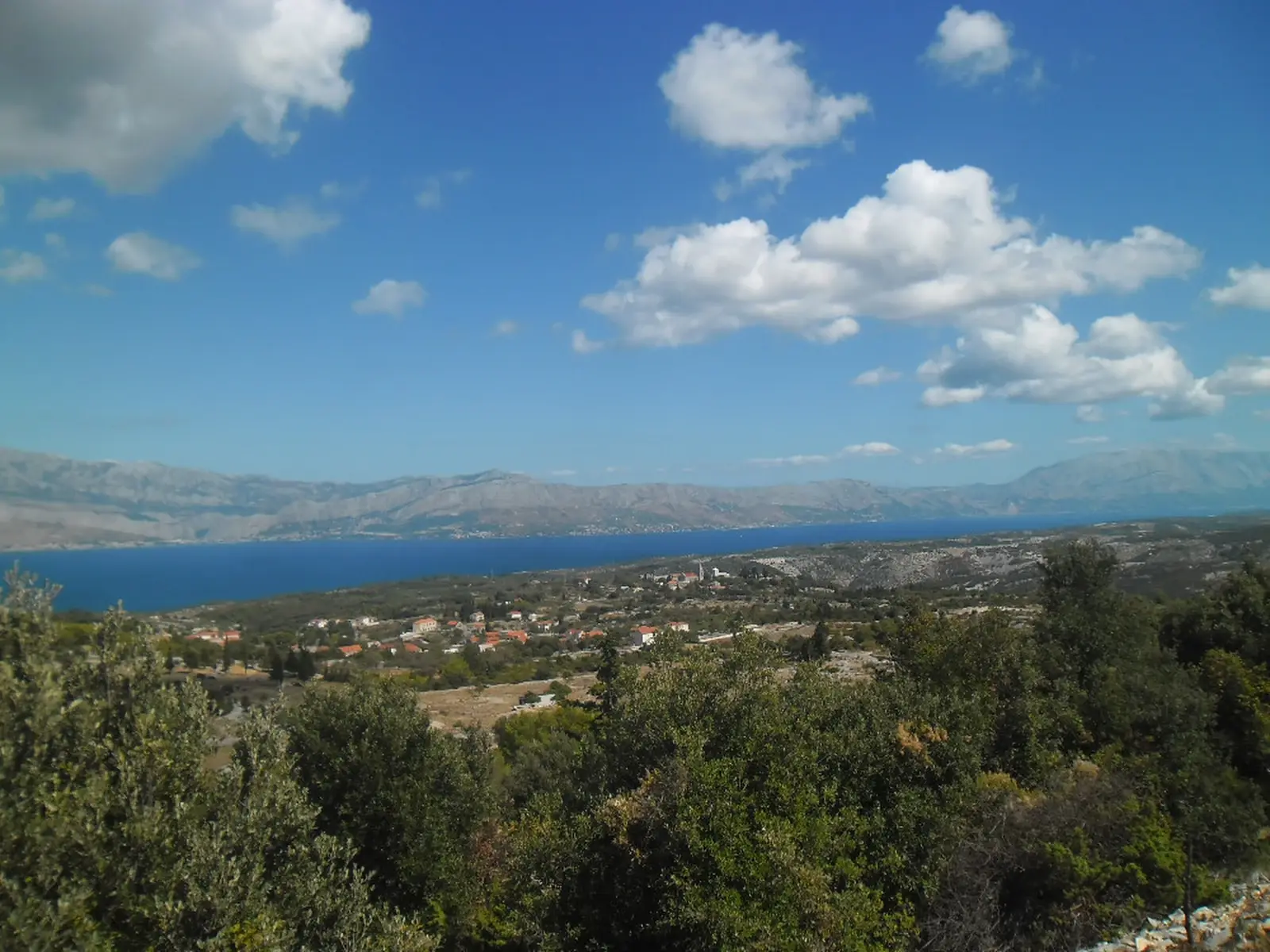 Landskap på ön Brač med Adriatiska havet och dalmatisk bebyggelse
